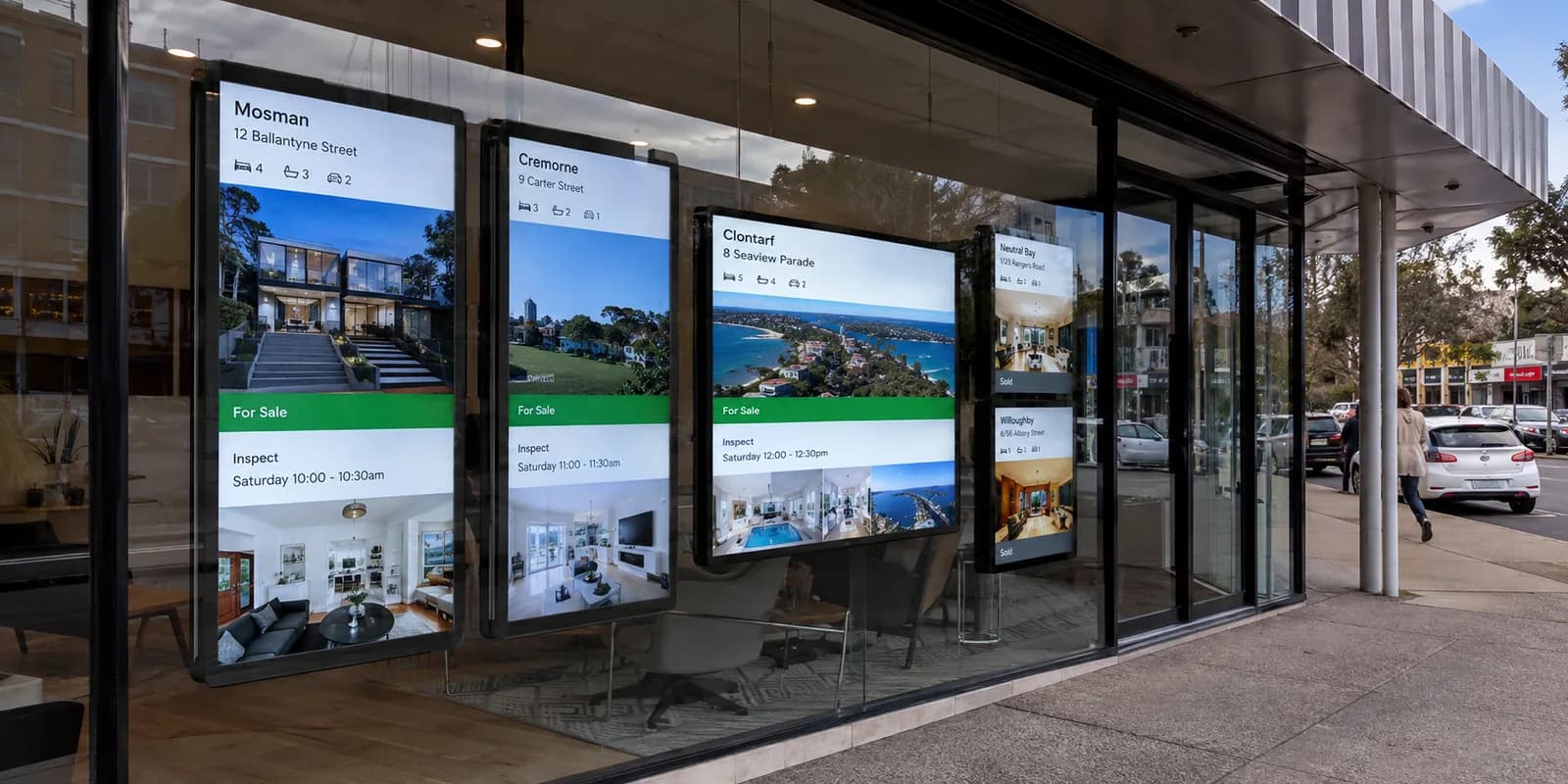 Australian real estate agency window with bright digital property listing displays