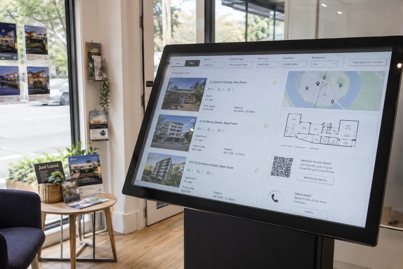 Interactive property finder kiosk inside a real estate agency with listings and floorplans