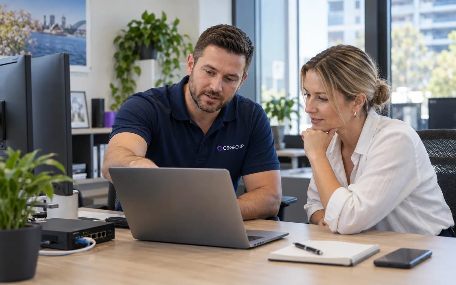 C9 GROUP technology specialist working alongside a customer in a modern workplace
