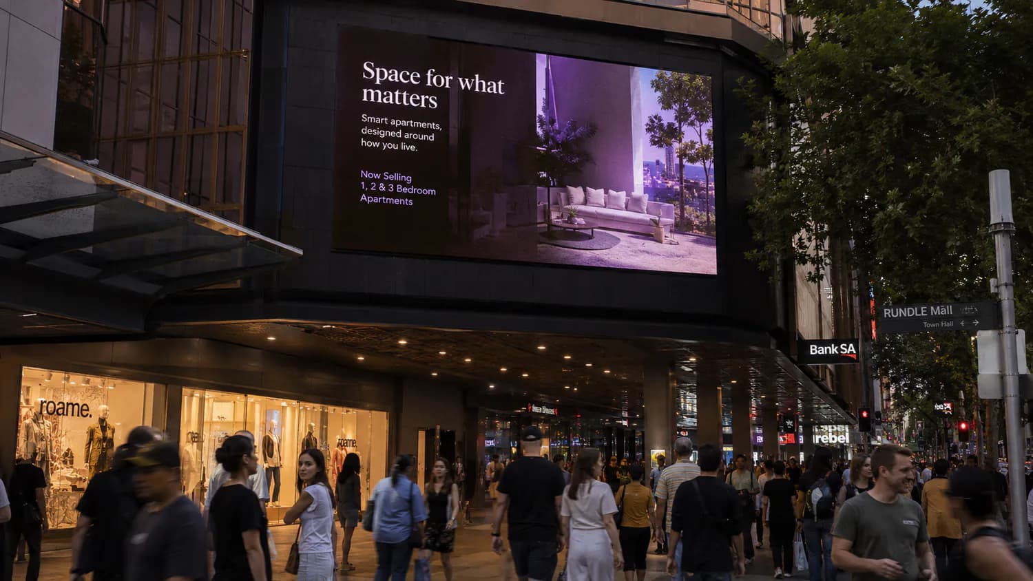 Outdoor LED display running above a busy retail street frontage