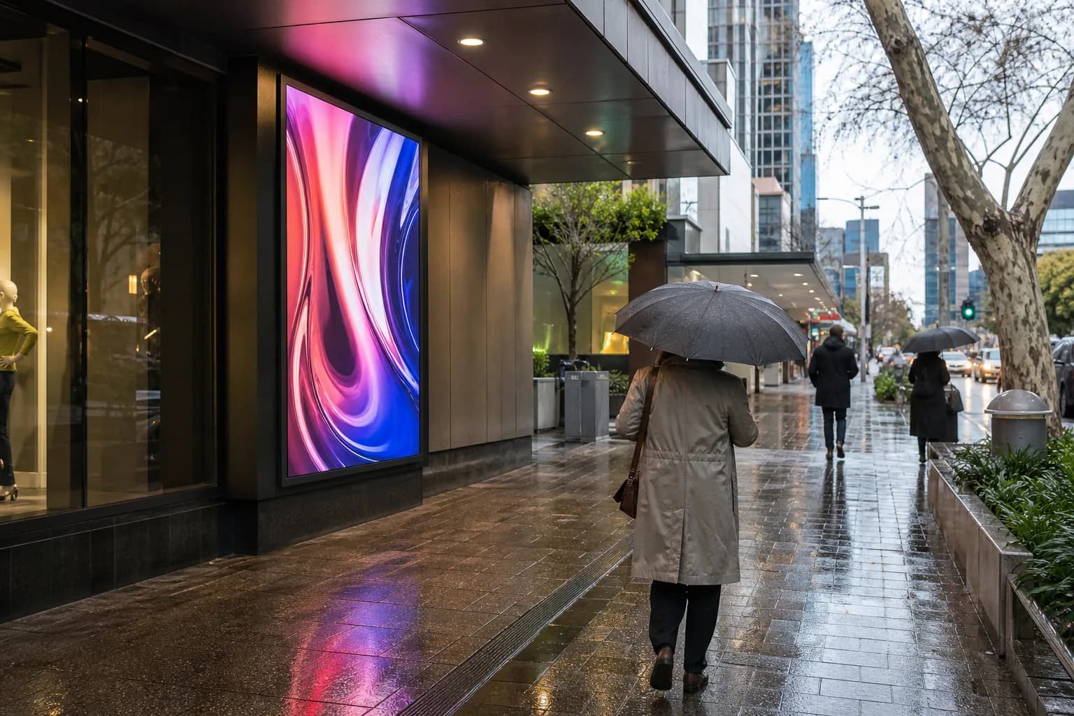 Outdoor LED display visible on a wet city footpath after rain